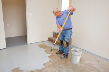 Painter painting garage floor.